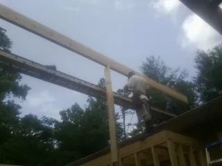 Carpenter setting a ridge beam over a new addition frame — Ice Dam Removal by Roofing Brothers in Lynchburg